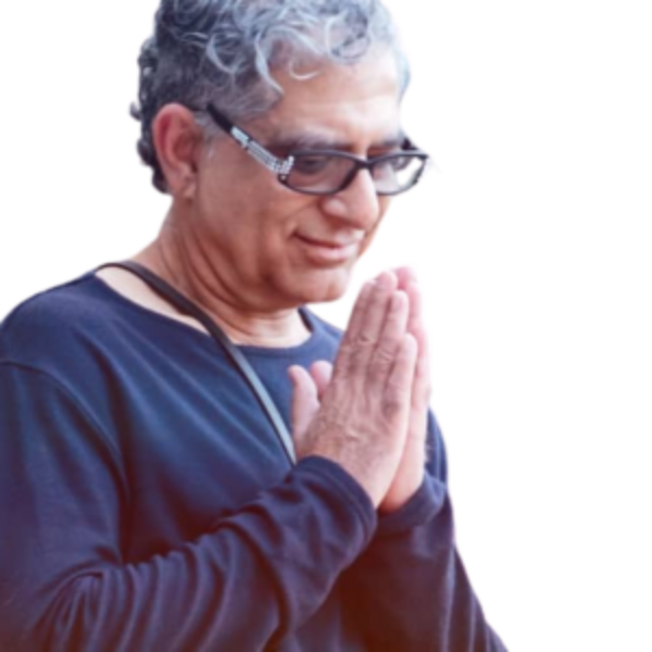 Deepak Chopra with his hands together in a prayer position.