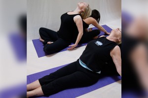 Four ladies doing yoga with each other at Forward Motion Yoga