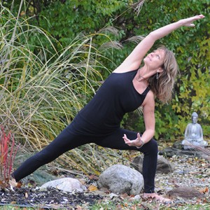 Cheryl Ward doing yoga in a green garden