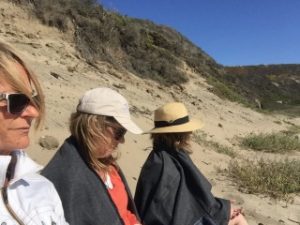 Cheryl Ward and two other Forward Motion Yoga instructors sitting on the beach.