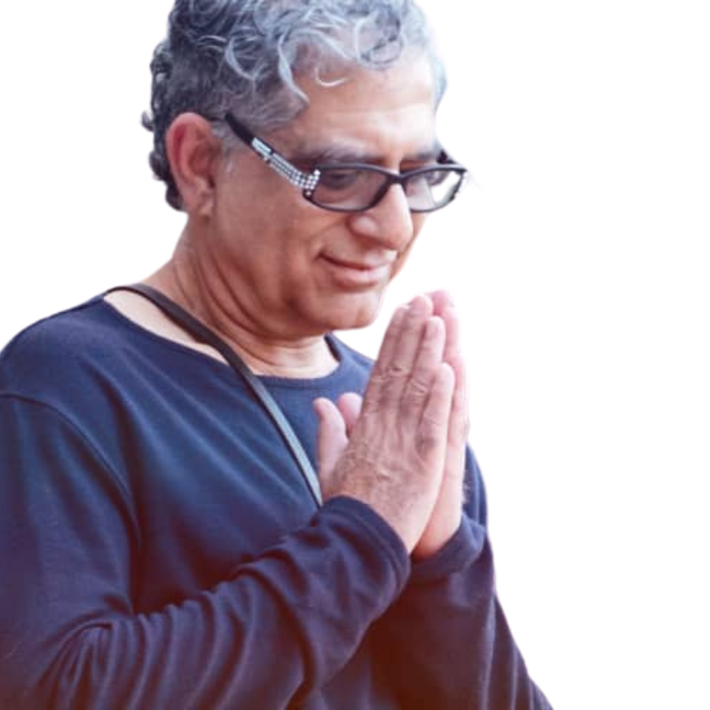 Deepak Chopra with his hands together in a prayer position.